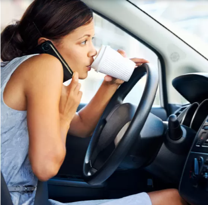distracted driver on phone and drinking coffee