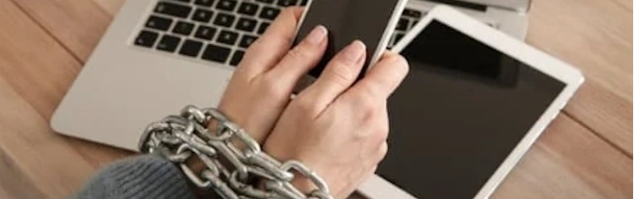 hands in chains holding cell phone